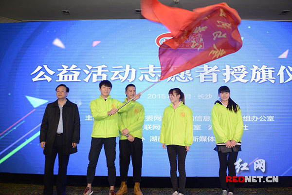 （湖南省人民政府副省长李友志为参加河道保洁的志愿者授旗。